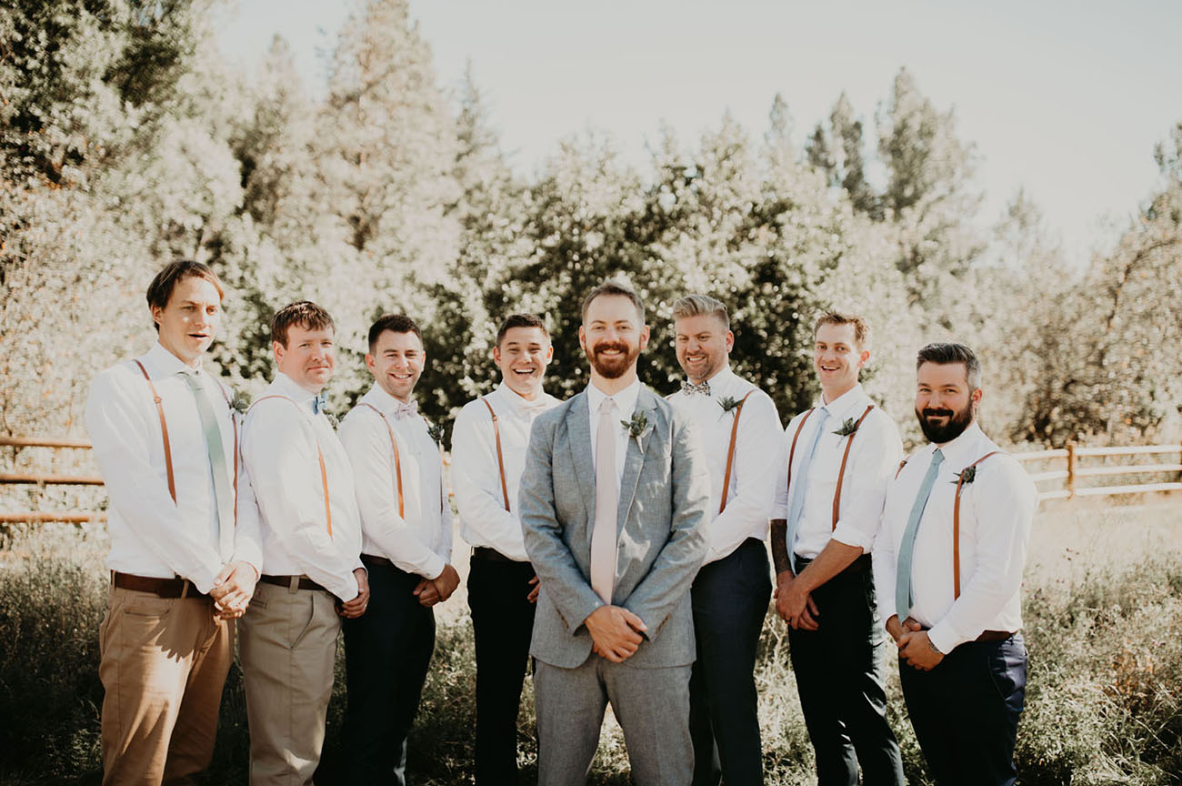 The groom was wearing a light grey suit with a blush tie, and the groomsmen were wearing suspenders and mint ties