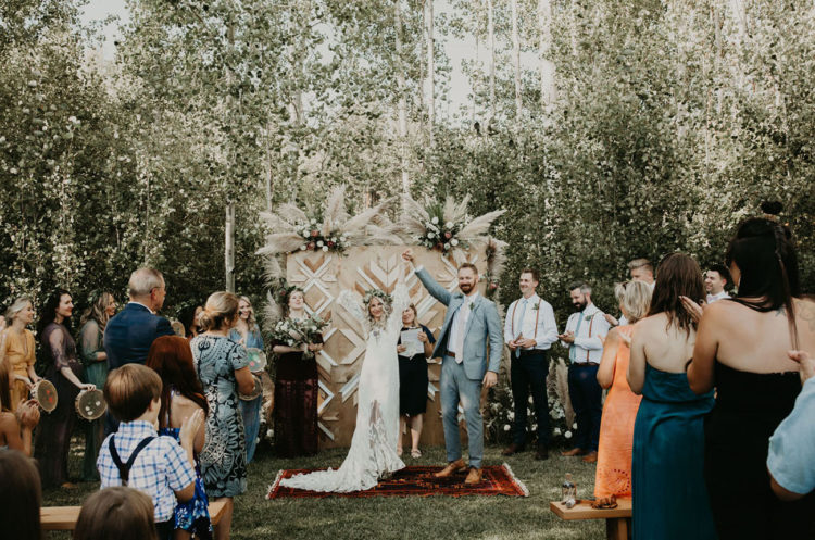 The wedding backdrop was done with catchy wooden chevron patterns and with blooms and pampas grass on top