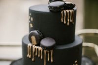 06 a matte black wedding cake with black macarons and gold drips looks very eye-catchy