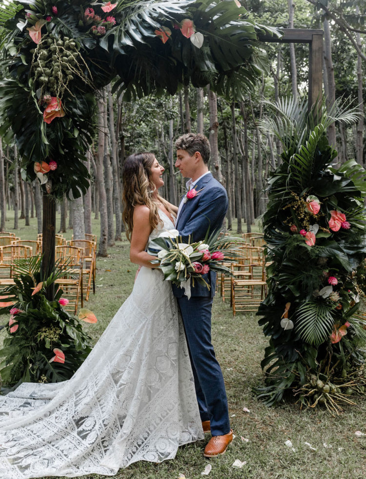 The wedding arch was done with tropical leaves and tropical pink blooms