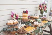 07 a simple rustic dessert table of wood, all covered with eucalyptus, with lots of bold blooms and desserts
