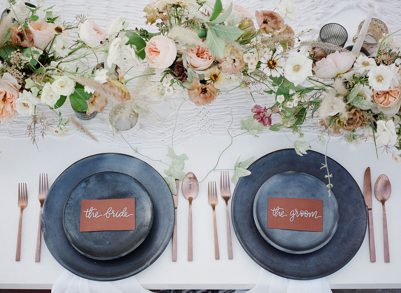The reception table was done with matte grey plates and chargers, delicate blooms, copper cutlery