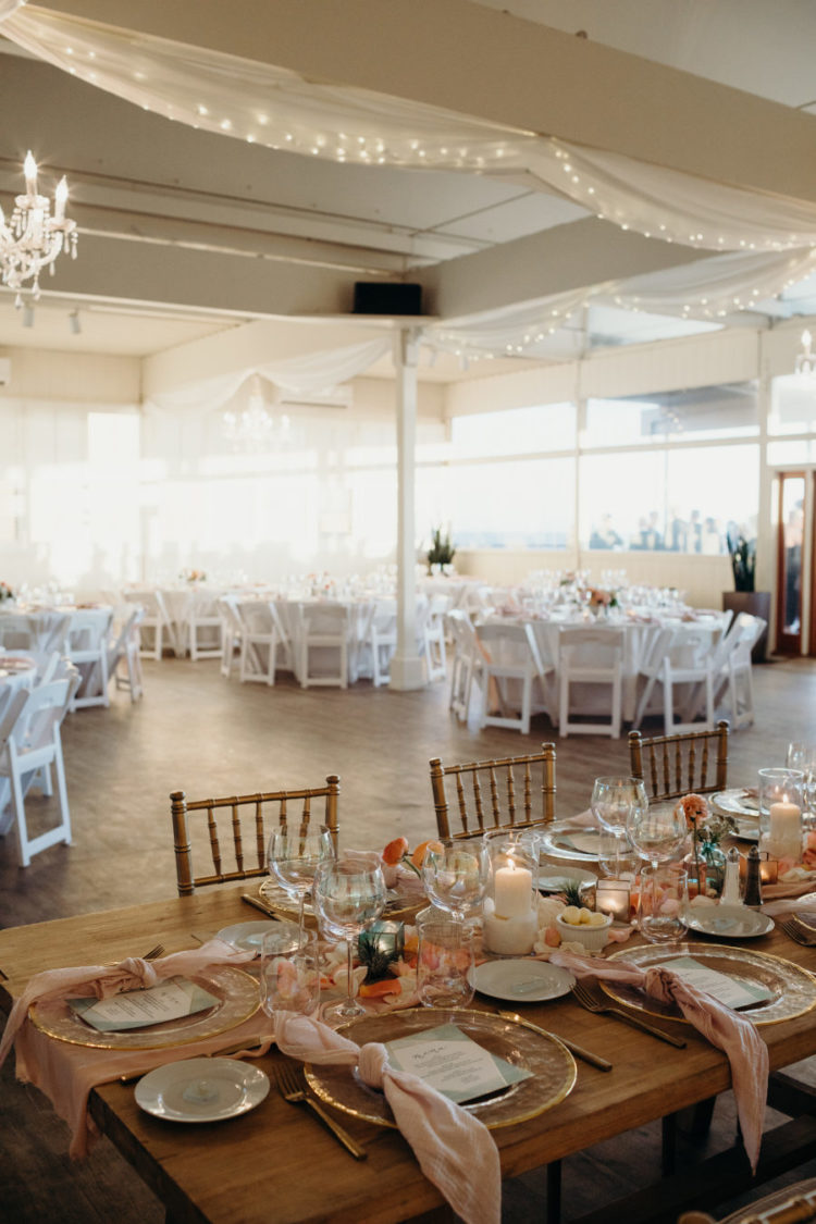 The tables were decorated with pastel blooms, gold rim chargers, blush napkins and candles
