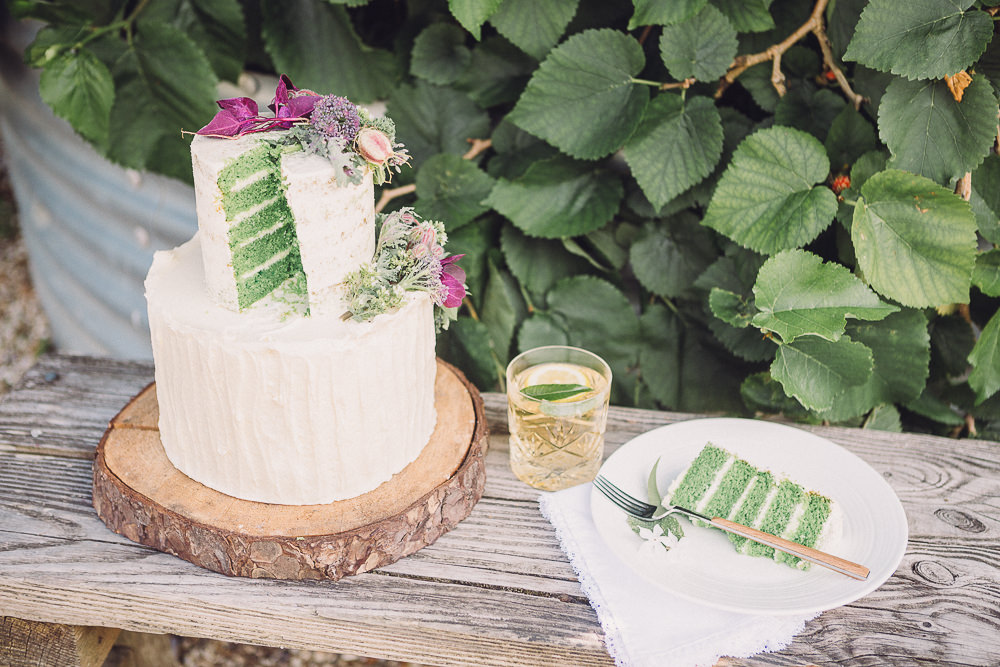 The wedding cake was a green layered sponge one with white frosting, topped with greenery and blooms