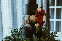 10 The wedding cake was a matte black one, with a floral tier and sugar and real blooms with a calligraphy topper