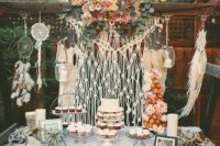 10 a boho backyard dessert table with a macrame backdrop and dream catchers, a crochet tablecloth and bold blooms