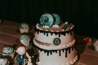 11 The wedding cake was a white one, with chocolate drip and turquoise cookies plus matching cupcakes