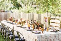 11 a cozy vintage rustic table setting with lush centerpieces and colored glasses plus vintage chairs