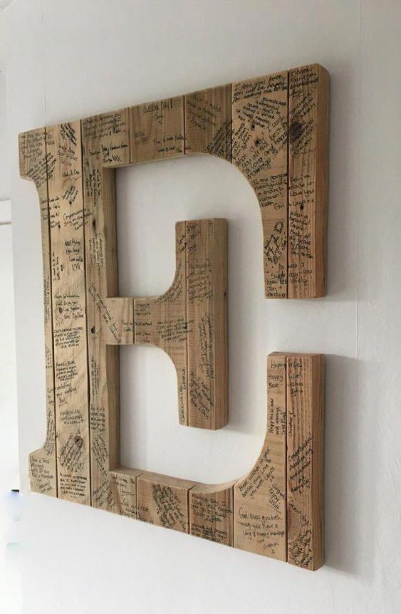 a wooden monogram signed by the guests can be used as an artwork, this is a cool and functional idea