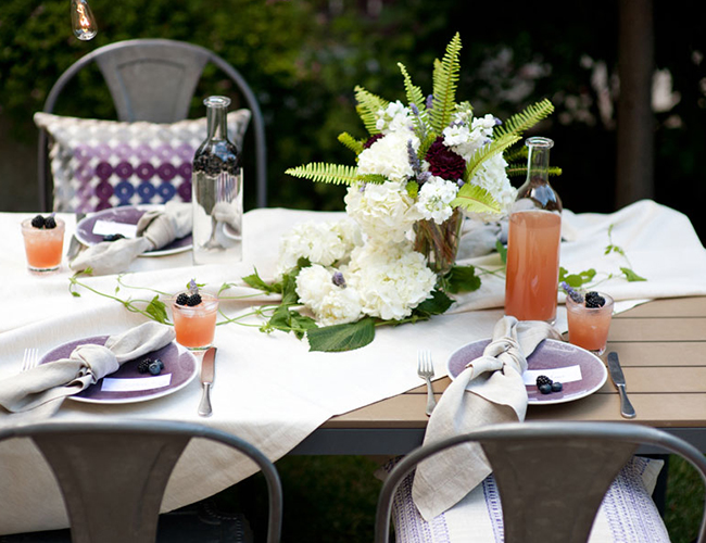 a cool table setting for an outdoor backyard bridal shower, fresh blooms and berries for decor