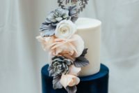 13 a color block wedding cake with a white and navy tier, with fresh and sugar blooms plus a topper