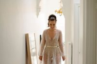 15 a neutral sheer wedding gown with embellishments all over it, a V-neckline, long sleeves and a bodysuit underneath