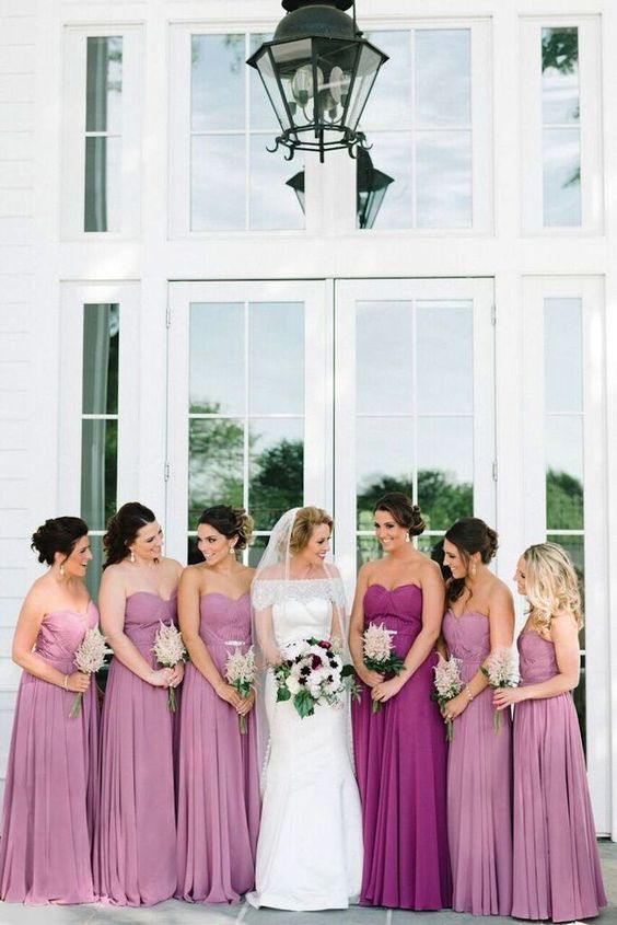 pink strapless maxi dress with pleated skirts and a purple matching gown for the maid of honor