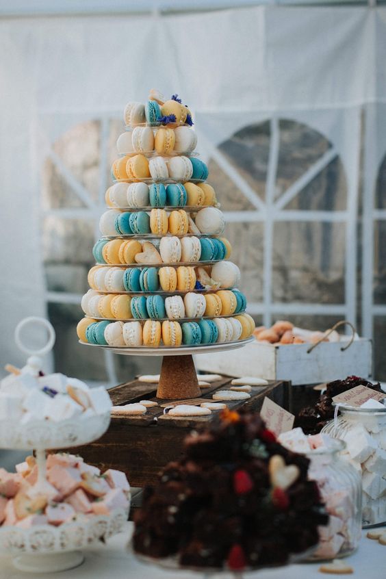 a colorful macaron and heart-shaped cookie tower with fresh blooms for decor