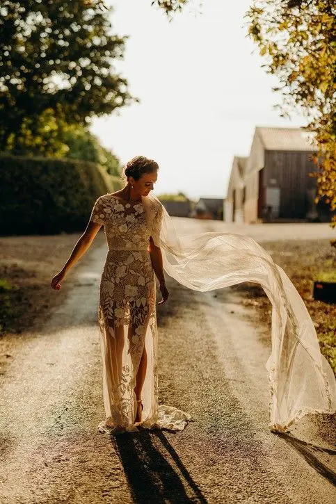 a catchy wedding dress with a sheer skirt and lace applique all over the dress, with a train and short sleeves is all cool