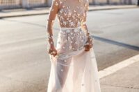 a modern naked wedding dress with all sheer everything and butterfly applique all over the dress, long sleeves and a train