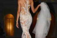 a naked wedding dress with lace applique that is strategically placed, a train and no sleeves accents the figure as much as possible
