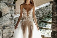 a romantic naked wedding dress with a lace bodice and depe neckline, a sheer skirt and spaghetti straps is wow