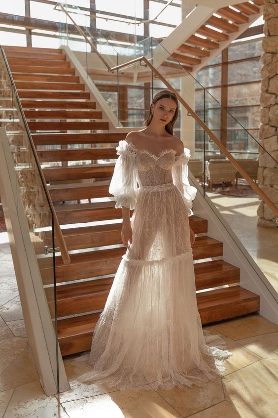 a romantic off the shoulder naked wedding dress with long sleeves and a train for a lovely vintage-inspired look