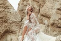 a sheer wedding dress with embroidery and lace appliques, with bell sleeves and slits for a boho bride