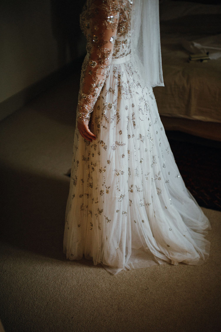 The bride was wearing a fully embellished wedding dress with an illusion neckline, long sleeves