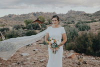 02 The bride was wearing a modern sheath wedding gown with short sleeves, a cutout back and a high neckline plus a long veil