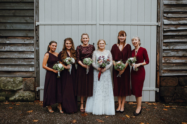 The bridesmaids were wearing mismatching burgundy and fuchsia dresses