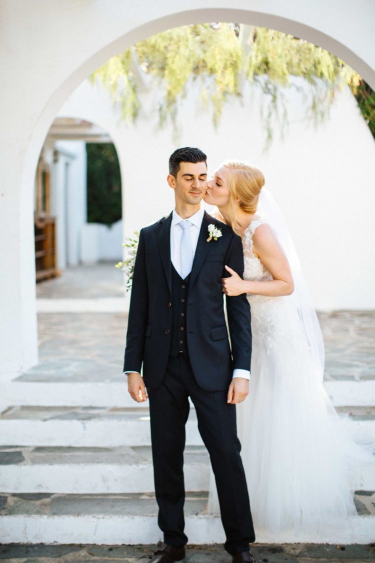 The groom was rocking a black three-piece wedding suit with a light blue tie, brown shoes and a neutral boutonniere