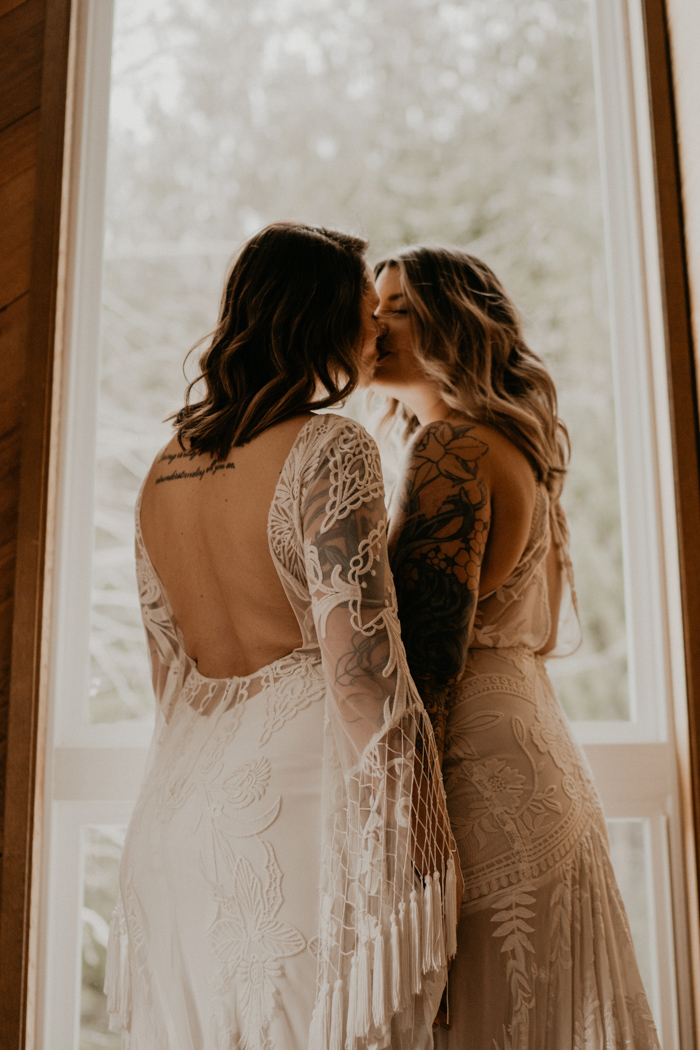 The wedding gowns showed off their tattoos perfectly and were of different yet rather similar designs