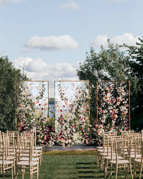 a modern bright floral wedding installation with three sheer walls and soem greenery is a gorgeous wedding backdrop
