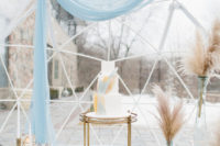 08 The cake was displayed with light blues, pampas grass, faux fur and geometric candle holders
