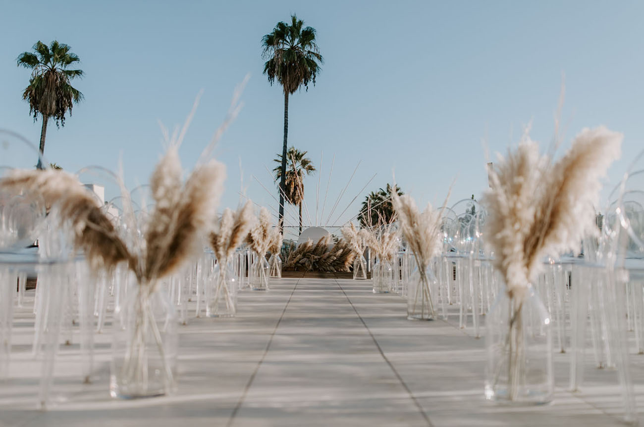 The ceremony space was done with ghost chairs and a vase with pampas grass