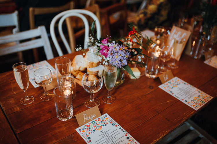 The wedding reception tables were done with bright blooms and bright menus