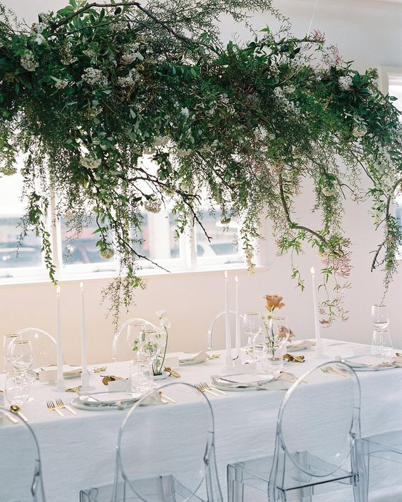 a lush greenery and white bloom wedding installation over the reception table for a refershing spring feel