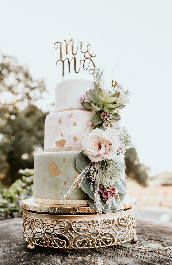 The wedding cake was done in white, marble pink and green plus metallic foil and lush blooms