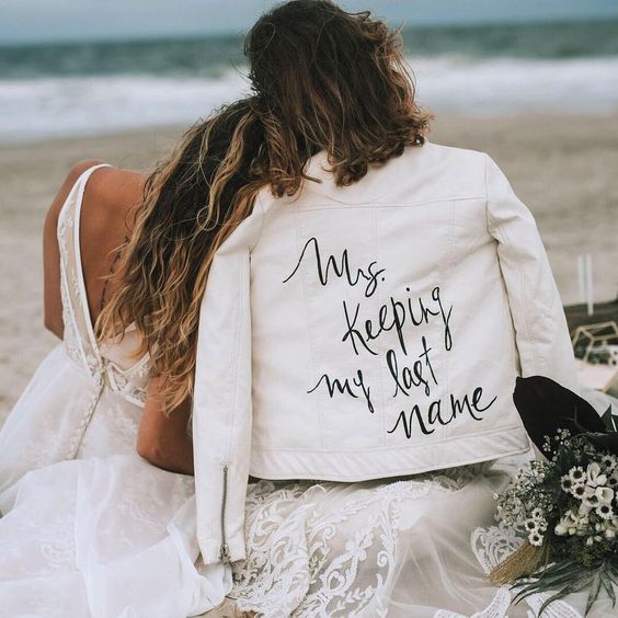 a white leather jacket with a fun inscription is a cool idea to wear for your wedding or for some shots