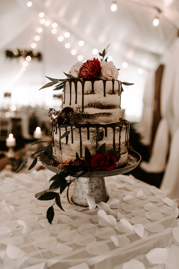 The wedding table was a naked one, with chocolate drip, burgundy and blush blooms plus greenery