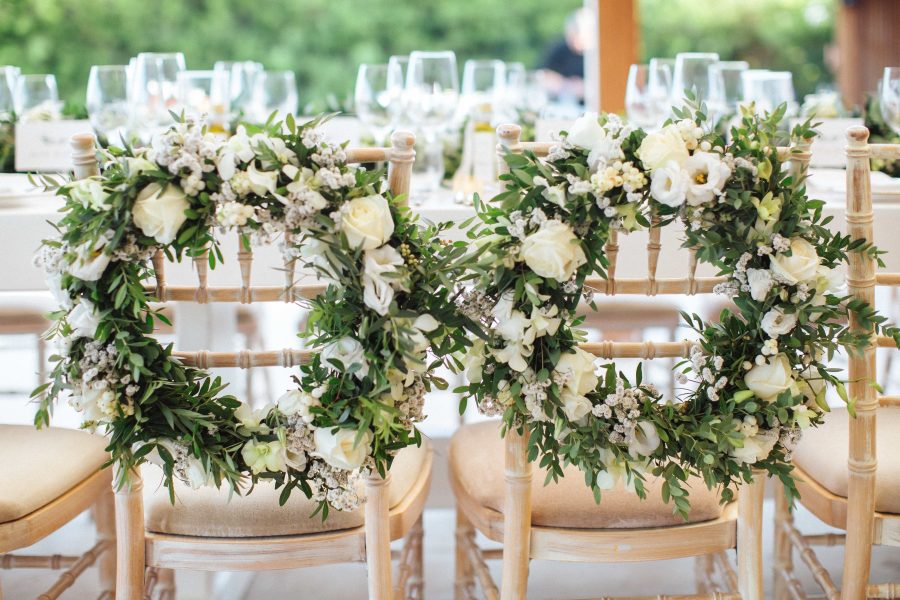 The wedding chairs were decorated with greenery and neutral bloom wreaths