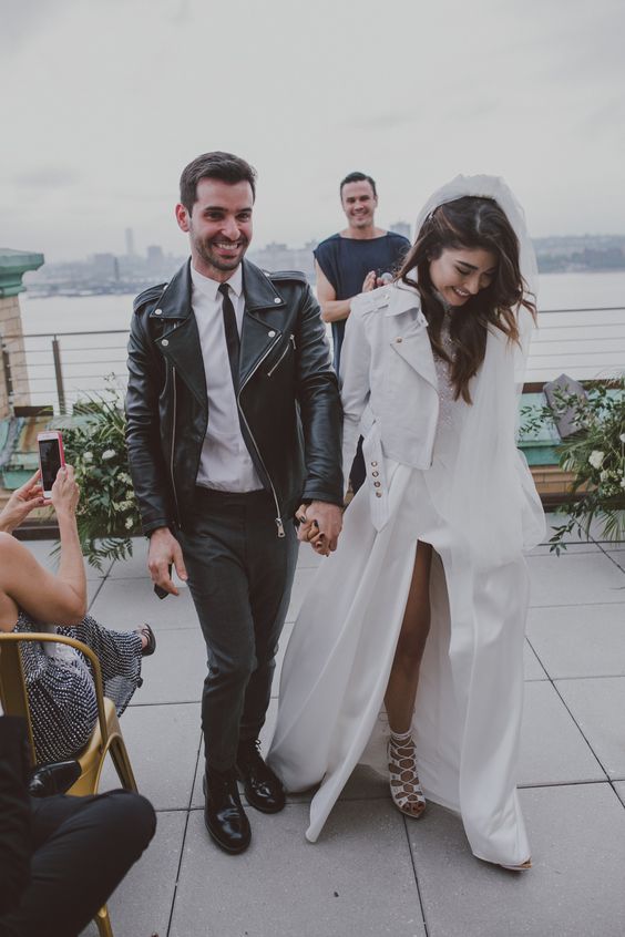 grey pants, a white shirt, a black leather moto jacket, black shoes for a modern and hot groom's look