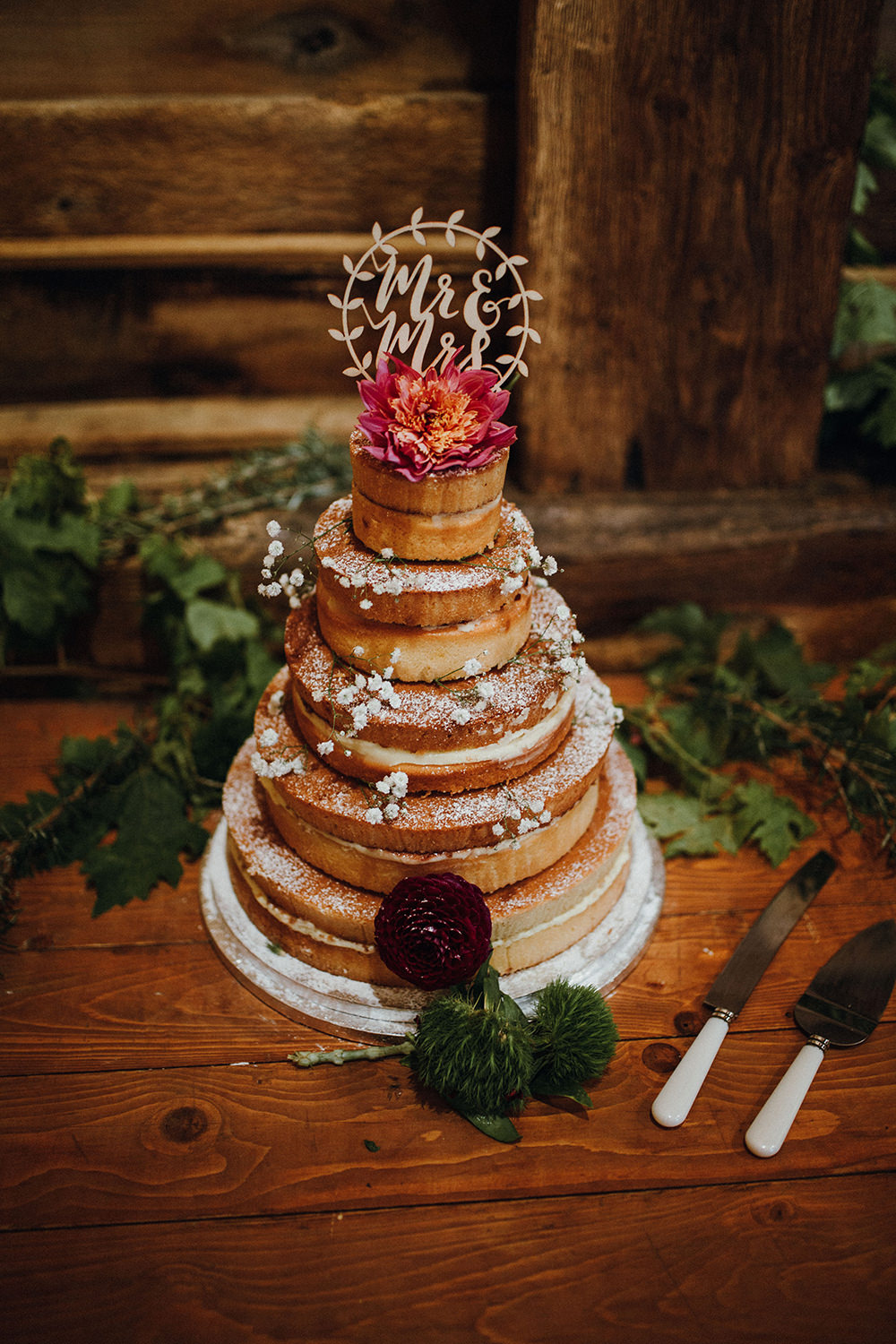The wedding cake was naked, with baby's breath, bold blooms and a cake topper