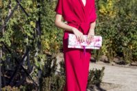 13 a bright fuchsia jumpsuit with wideleg pants, a V-neckline and ties plus a bright floral clutch