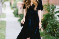 15 a navy velvet wrap midi dress with short sleeves and an asymmetrical skirt, light blue shoes and a black bag