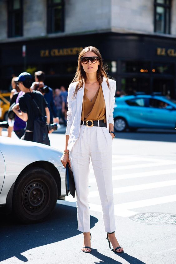 a pure white pantsuit with an oversized blazer, teal heels, a teal bag, a camel draped top