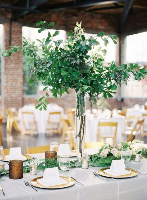 a lush and tall greenery centerpiece of branches and leaves is a very modern idea