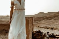 26 a shiny boho lace wedding gown with gold pompoms on the waist and matching pompom arm band sleeves