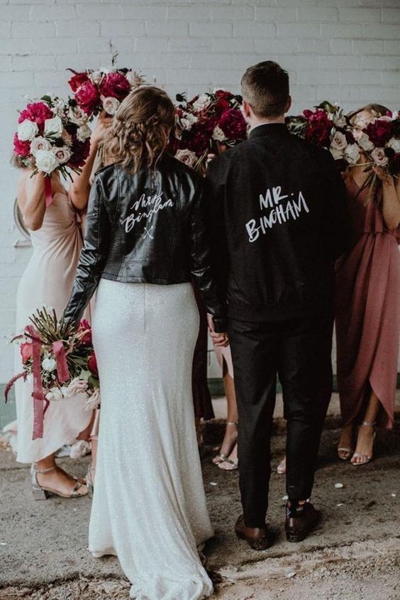 a black denim groom's jacket personalized for him with his nname is a cool idea, and it matches the bride's jacket