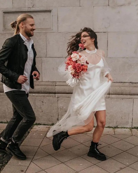 a creative groom's look with a white shirt, black jeans and boots, a black leather jacket is a cool idea for an edgy wedding