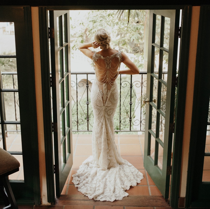 The bride was wearing a fantastic lace mermaid wedding dress with a cutout back with chains and embellishments and a train