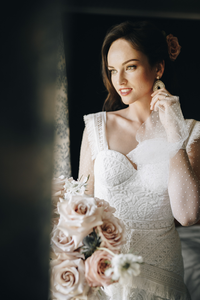 The bride was wearing a patterned wedding gown with fringe, sheer polka dot sleeves