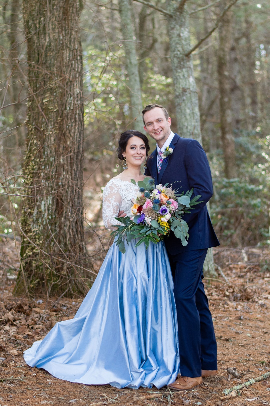 The bride was wearing a white lace off the shoulder top and a blue full skirt, the groom was wearing a bright blue suit with a colorful floral tie
